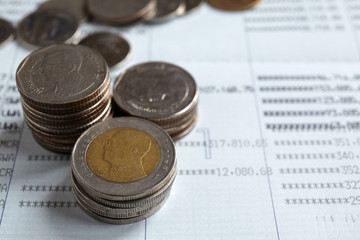 Coins stack on passbook, saving or investment concept.