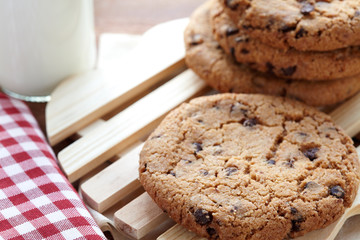 Chocolate chips cookies with milk bottle in background on the wooden table. quick and eays meal in the morning. Close up shot.