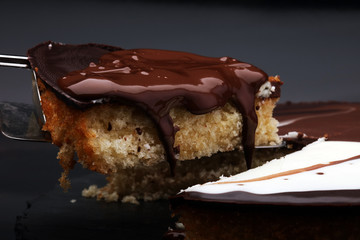 Delicious chocolate cake on dark background with cocoa beans