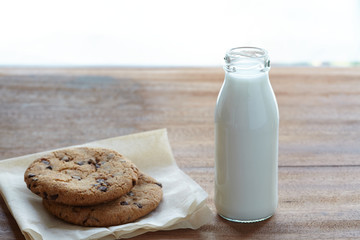 Milk in the bottle with chocolate chips on the wooden table. easy breakfast with healthy.