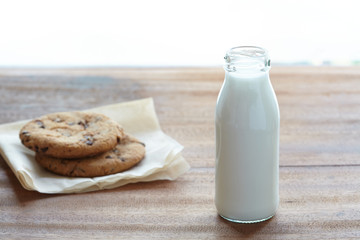 Milk in the bottle with chocolate chips on the wooden table. easy breakfast with healthy.