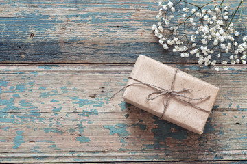 Rustic gift box with floweron the old grunge painted boards. Place for text.