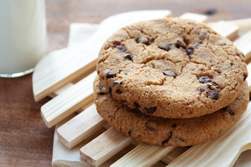 Chocolate chips cookies with milk bottle in background on the wooden table. quick and easy meal in the morning. Close up shot.