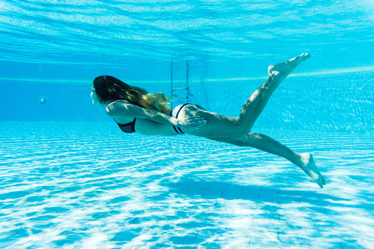 girl dive under blue water snorkeling in pool. Summer vocation