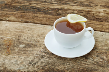 cup of tea with lemon on wooden background