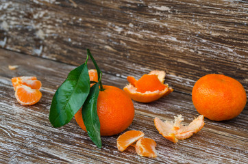 Close up of whole mandarin with leaves,  mandarin slice and mandarin peel on wood table. Organic...