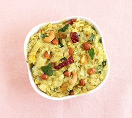 Indian traditional and popular snack poha chivda made from frying items like thin flattened rice, red chili, curry leaves, groundnuts, cashew nuts and almonds.