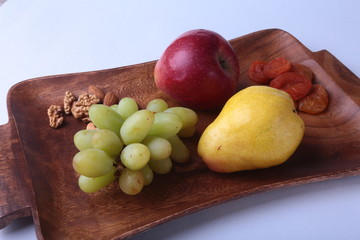 Fresh organic fruits on wood Serving tray. Assorted apple, pear and grapes.