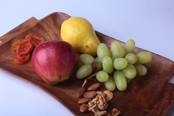 Fresh organic fruits on wood Serving tray. Assorted apple, pear and grapes.