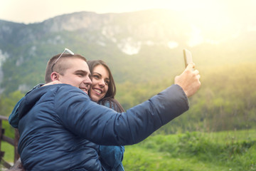 Couple taking selfie with smartphone in the nature in spring