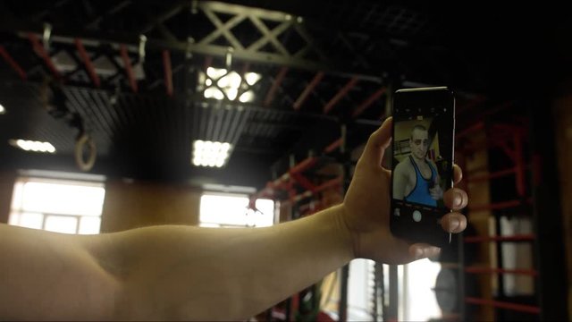 The athlete makes a selfie photo in the hall of crossfit