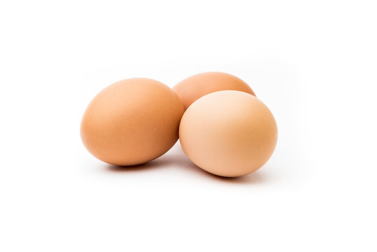 Tres huevos morenos con fondo blanco