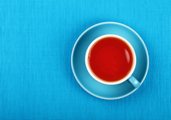 Full black tea in blue cup close up top view