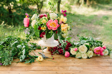 bouquet, holiday flower, gift and floral arrangement concept - composing a wonderful bouquet in white vase on wooden table in garden, cut flowers, white and yellow roses, pink peonies, red carnations