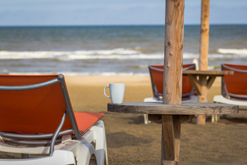 Cup of coffee on the beach after rain.