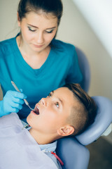 Obraz na płótnie Canvas Hansome teenager boy having his teeth examined by a dentist
