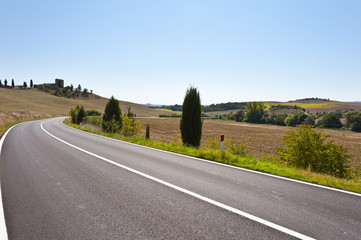 Asphalt road between fields in Italy