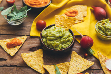 Fresh ingredients for homemade guacamole (avocado, tomato, salt) on wooden background. top view. Healthy food background