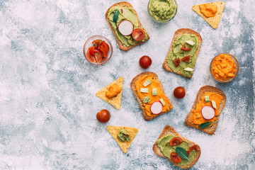 Fresh avocado guacamole on diet bread slices with healthy ingredients