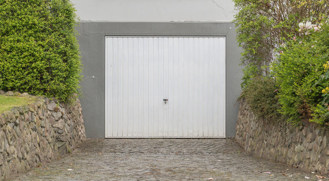 Weißes Garagentor mit grauer Fassade