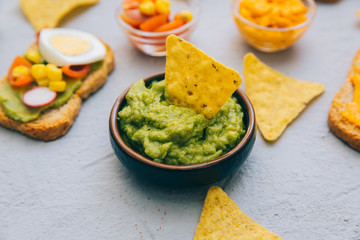 Fresh ingredients for homemade guacamole (avocado, tomato, salt) on background. top view. Healthy food background with space for text.