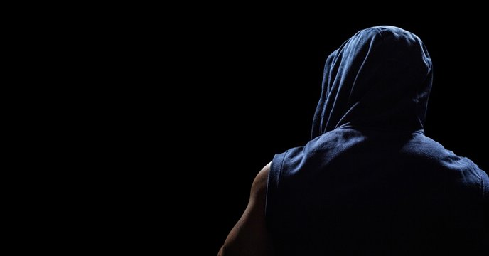 Back Of Man In Hoodie Against Black Background