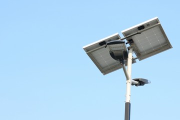 Street lamp post with solar panel energy (against blue sky background)