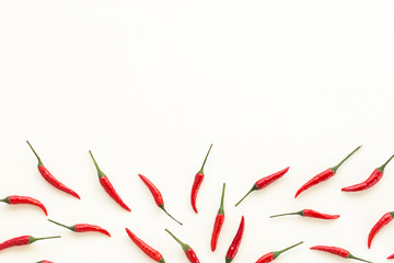 red hot chili peppers, popular spices concept - beautiful handful of red hot pepper pods scattered on white background, top view, flat lay, empty space for the text