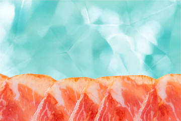 Slices of marbled meat on a light background with bokeh. Ham lomo from the sight of pigs of the Pata Negra. Spanish cuisine.