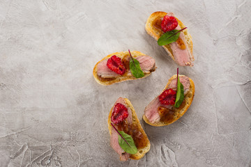 Bruschetta sandwiches with duck meat and berries
