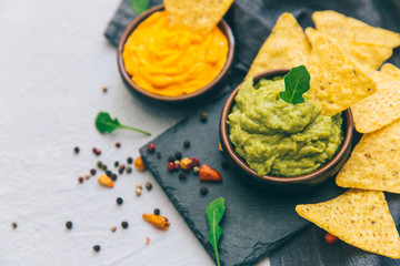 nachos with guacamole on a gray background.