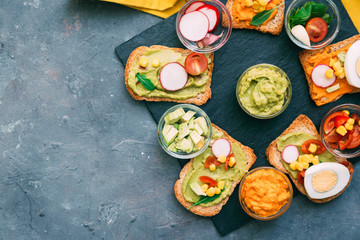 Diet toast on gluten-free loaves - with guacamole and fresh vegetables. Top view. Copy space