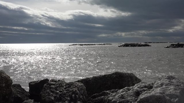 Foamy waves of a grayish sea on a cloudy and windy winter day on the coast of the Adriatic Riviera in Italy