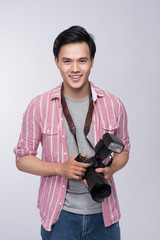 Young asian photographer holding digital camera, while working in studio