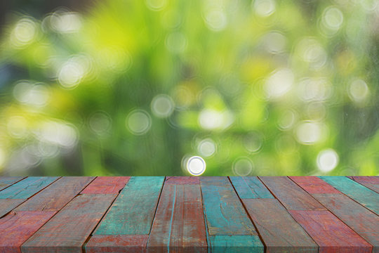 Selected focus empty wooden table and view of green forest blur background with bokeh image. for your photomontage or product display.