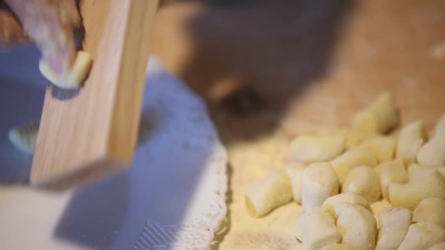 Preparazione degli gnocchi di patate fatti in casa a mano su un tagliere di legno