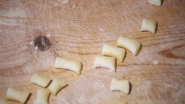 Preparazione degli gnocchi di patate fatti in casa a mano su un tagliere di legno