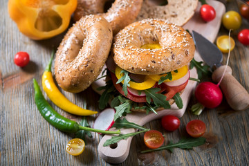 Vegetarian bagel sandwich with fresh veggies and arugula, healthy vegan snack