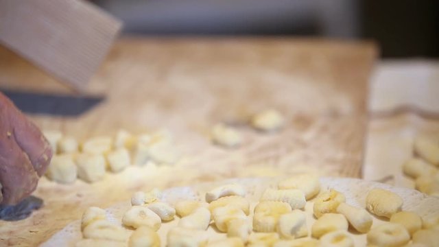 Preparazione degli gnocchi di patate fatti in casa a mano su un tagliere di legno