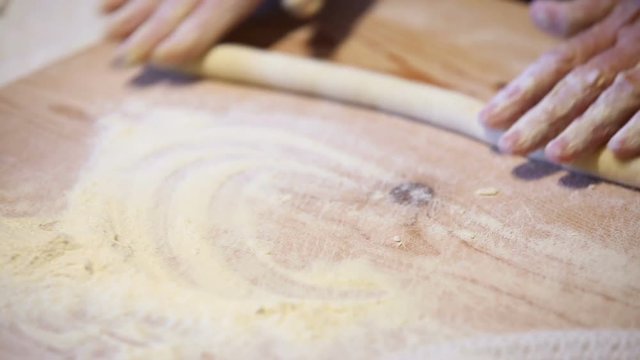 Preparazione degli gnocchi di patate fatti in casa a mano su un tagliere di legno