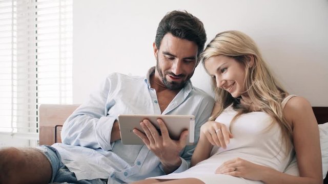 Couple sitting on sofa with touchpad