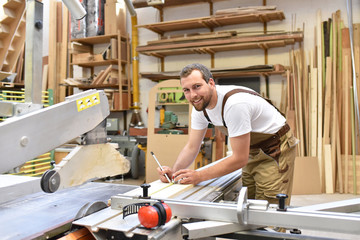 Tischler arbeitet an einer Säge in einer Schreinerei // Carpentry working on a saw in a...