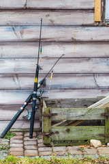 Two fishing rods and wooden box standing outside
