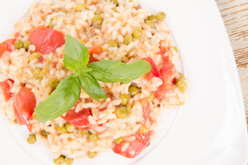 Risotto with tomato and pea on a wooden background 