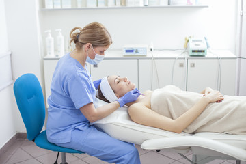 Fototapeta premium Young beautiful woman in the beauty salon on the face treatment