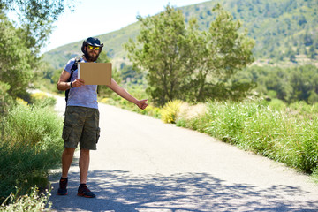 Fototapeta na wymiar Hitch-hiking traveler with a blank cardboard sign
