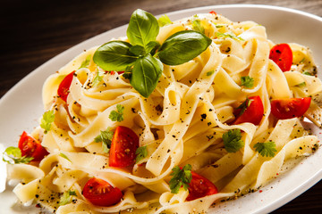 Pasta with tomatoes on wooden table