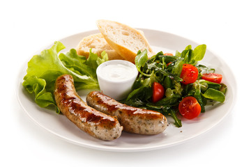 Grilled sausages with vegetables on white background