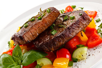 Grilled beefsteak with vegetables on white background