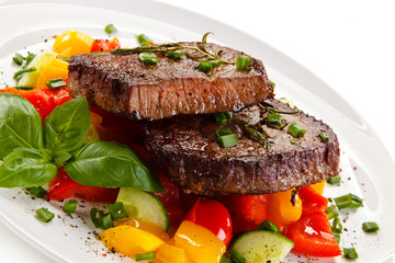 Grilled beefsteak with vegetables on white background